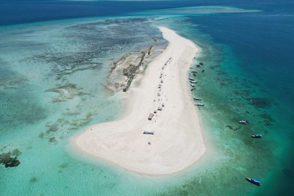 Banco de arena en Zanzíbar rodeado de aguas turquesas y barcos locales